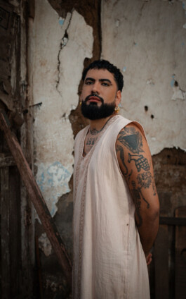 Portrait des Künstlers Elyla für die Biennale für Freiburg 3, 2025. Die Person trägt ein weißes Gewand. 