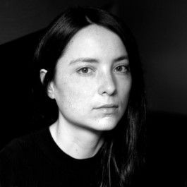 Portrait der Künstlerin Paloma Contreras Lomas für die Biennale für Freiburg 3, 2025. Das Bad ist schwarz-weiß und sie schaut seitlich in die Kamera. 